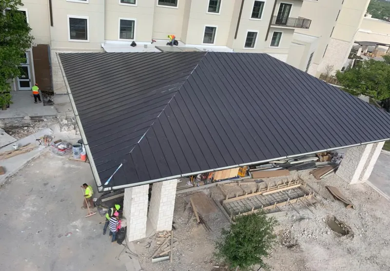 Metal roofing installation team working on a commercial building in Coral Gables
